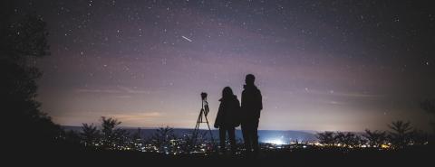 Zwei Personen betrachten den Nachthimmel